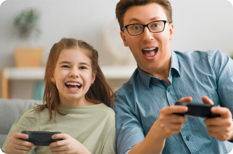 daughter and father sitting on the couch playing video games